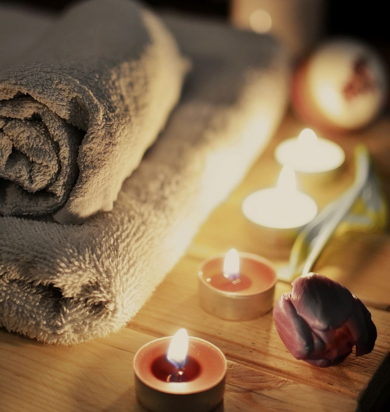 Ritual Silvestre: velas encendidas, madera cálida y textil sobre una mesa baja.